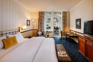 a hotel room with a large bed and a desk at Opera Hotel Zürich in Zürich