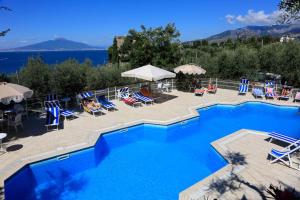 a large swimming pool with chairs and umbrellas at Camping Nube D'Argento in Sorrento