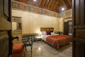 sypialnia z łóżkiem i stołem w pokoju w obiekcie La casa del Cipres una casa con historia w Kordobie