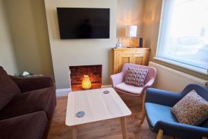 a living room with a couch and a table and a fireplace at NEW 2BD Victorian Terraced House Loughborough in Loughborough