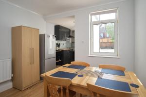 a kitchen with a wooden table and a refrigerator at NEW 2BD Victorian Terraced House Loughborough in Loughborough