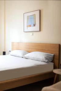 a bed with a wooden headboard in a bedroom at Thalassa in Agios Nikolaos +2 photos