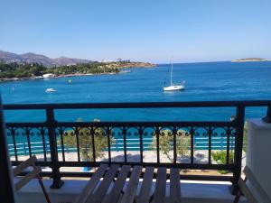 a view of the ocean from a balcony with a boat at Thalassa in Agios Nikolaos