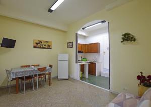 a kitchen and dining room with a table and a refrigerator at Les Suites Corso Roma in Gallipoli