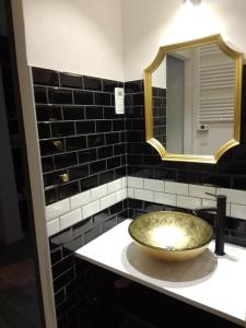 La salle de bains est pourvue d'un lavabo en or et d'un miroir. dans l'établissement LE GEORGE SAND Elégant studio coeur historique, à Bourges