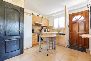 a kitchen with a wooden door and a table at La Granja - Maison avec cheminée, jardin, baby-foot in Formiguères