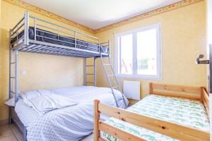- une chambre avec 2 lits superposés et une fenêtre dans l'établissement La Granja - Maison avec cheminée, jardin, baby-foot, à Formiguères