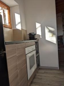 a kitchen with a stove and a dishwasher at La casetta nel bosco in Salò
