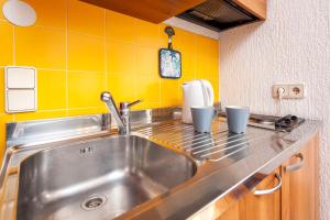a kitchen counter with a sink and cups on it at Guesthouse Ava in Rovinj