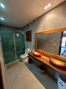 Un baño con lavabo, ducha e inodoro. en Vila Ybytu Eco Resort, en Itarema