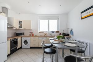 a kitchen with a table and chairs in it at Les Bleuets - Duplex avec vue mer in Pléneuf-Val-André +5 photos