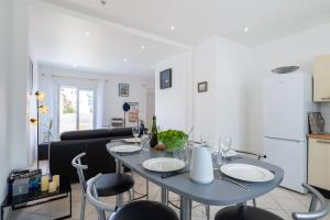 a dining room and kitchen with a table and chairs at Les Bleuets - Duplex avec vue mer in Pléneuf-Val-André