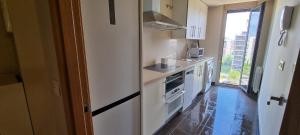 cocina con electrodomésticos blancos y ventana grande en APARTAMENTO CAMP DE MORVEDRE, en Castellón de la Plana