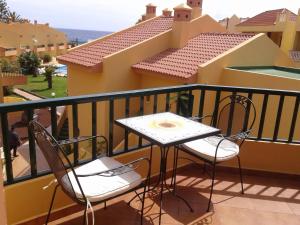 een tafel en stoelen op een balkon met uitzicht bij Gepflegte Apartment-Anlage mit Pool und Garten in La Playa Calera