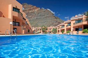 een groot zwembad met een berg op de achtergrond bij Gepflegte Apartment-Anlage mit Pool und Garten in La Playa Calera