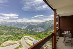 a balcony with a view of a road and mountains at Pégase Phénix in Le Corbier