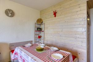 a dining room with a table with a red and white table cloth at Pégase Phénix in Le Corbier