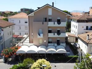 un bâtiment avec des auvents blancs dans une ville dans l'établissement Hotel Villa Dina, à Rimini