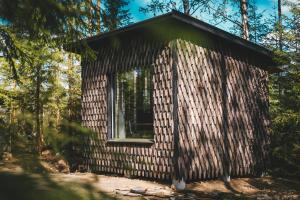 a small log cabin in the woods with a window at Venejoen Piilo - Loimu in Kontiolahti