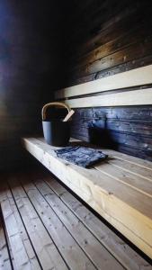 a bucket sitting on a wooden bench in a room at Venejoen Piilo - Loimu in Kontiolahti