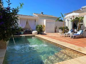 a swimming pool in front of a house at La Siesta in Estepona