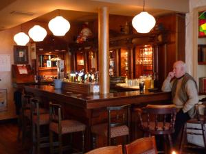 a man standing at a bar in a pub at Holiday Hotel in Galway