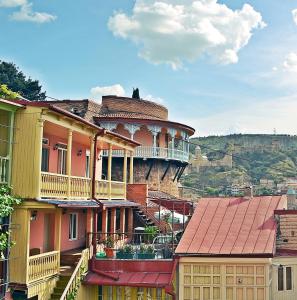 ein Gebäude mit Balkon auf einem Hügel in der Unterkunft Apartment Paysage in Tbilisi City