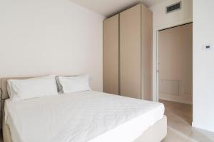 1 dormitorio con cama blanca y armario en LUVI - Flavio Gioia, en Milán