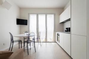 una cucina e una sala da pranzo con tavolo e sedie di LUVI - Flavio Gioia a Milano