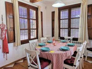 a dining room with a table and chairs and windows at Domicilio de Vida in Ricote