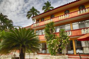 een gebouw met palmbomen ervoor bij Rincon del Pacifico in Puerto Escondido