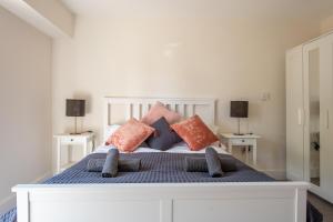 a white bed with pillows on top of it at Modern, well placed house walkable to beach & town in Lyme Regis