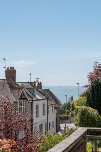 Un grupo de casas con el océano al fondo en 1 Dorset Mews, en Lyme Regis