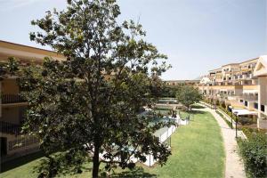 un complejo de apartamentos con un árbol y una piscina en Apartamento La Golondrina, en Marbella