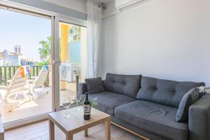 sala de estar con sofá y mesa con copas de vino en Apartamento La Golondrina, en Marbella