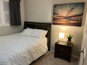 a bedroom with a bed and a table with a lamp at Experience Raleigh NC 8 minutes from the heart in Raleigh