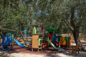 a park with a playground with a slide and a play structure at Ferienwohnung ulivo mit Pool und Privatstrand -1 in Mattinata