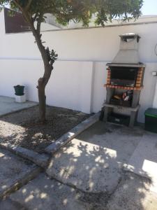 a tree in a yard with a grill at Casa da Praia Alfarim in Sesimbra +58 photos