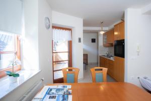 a kitchen with a wooden table and two chairs and a table and a kitchen at Apartment Tinka Kranjska Gora in Kranjska Gora