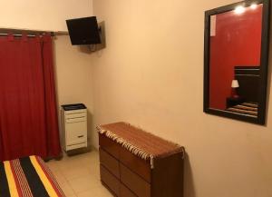 a room with a mirror and a dresser and a red curtain at Complejo Dolce Clementina in San Clemente del Tuyú
