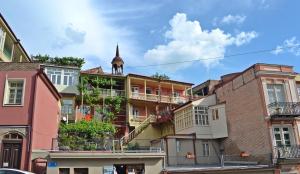a group of buildings with a church steeple in the background at Apartment Paysage in Tbilisi City