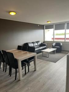 a living room with a table and chairs and a couch at Reykjavík Condo in Reykjavík