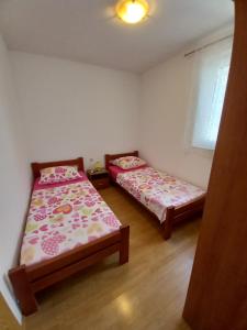 a bedroom with two beds and a window at House Marina 30m from the sea in Sveta Nedelja