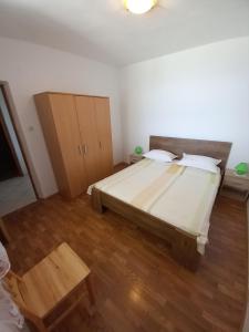 1 dormitorio con 1 cama grande y suelo de madera en House Marina 30m from the sea en Sveta Nedelja