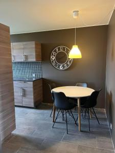 uma sala de jantar com uma mesa e um relógio na parede em Reykjavík Condo em Reykjavík