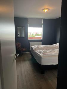um pequeno quarto com uma cama e uma janela em Reykjavík Condo em Reykjavík