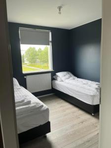 Duas camas num quarto com uma janela em Reykjavík Condo em Reykjavík