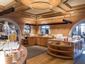 a large kitchen with wooden walls and wooden floors at Hotel & Spa Sonne 4 Sterne Superior in Kirchberg in Tirol