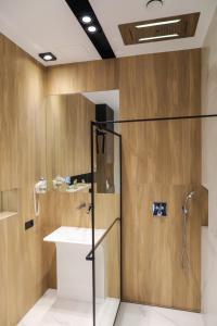 La salle de bains est pourvue d'une douche et d'un lavabo. dans l'établissement Apartament Księżycowy z jacuzzi, à Nowy Sącz