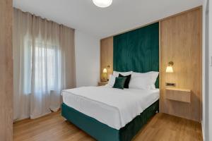 a bedroom with a large bed with a green headboard at 1-2. Luxury Apartments L&L Tucepi - 100m from the beach in Tučepi